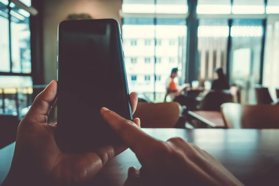 Professional consultant recording a meeting with a client with his phone safely and efficiently, with Summary AI app.