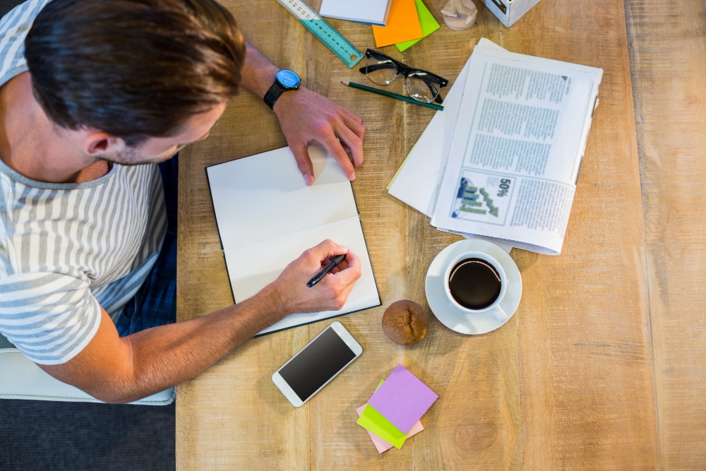 man with papers and notebook creating an article summary