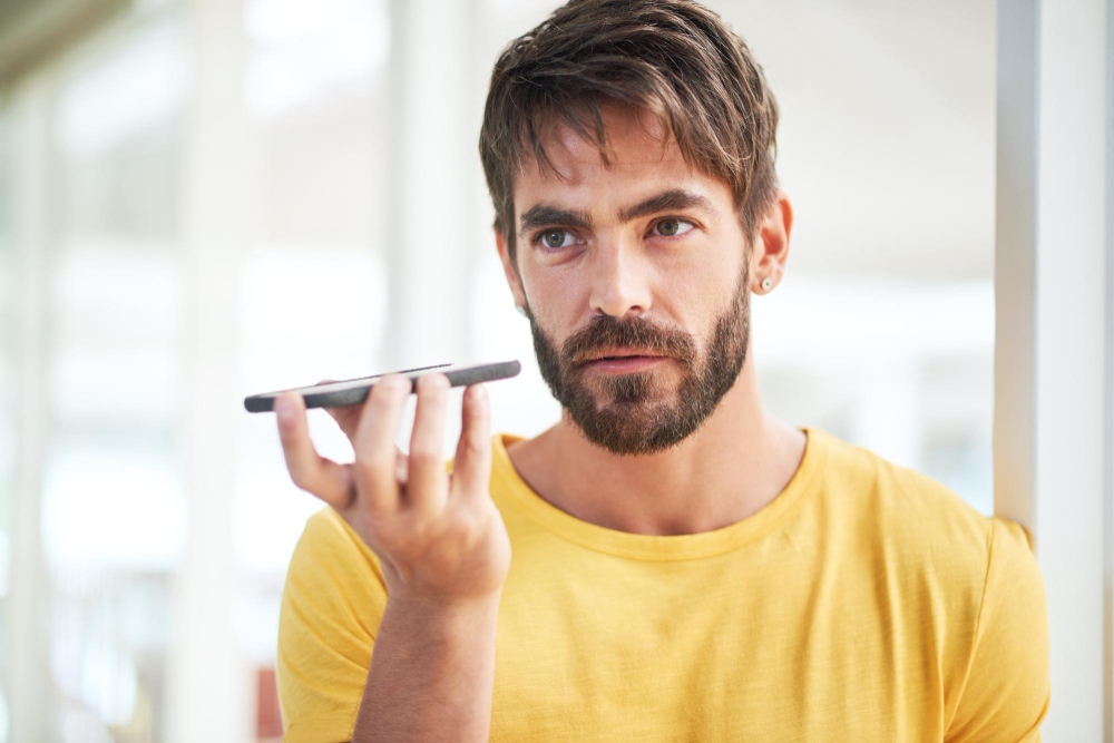 man holding phone and recording sound on it