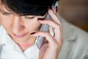 Person recording a phone call on an iPhone using speaker mode