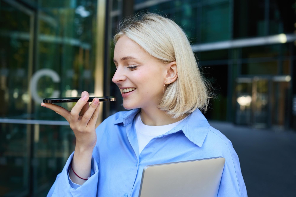 Person speaking to an AI voice assistant on a smartphone