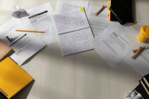 desk with notebooks papers and pens