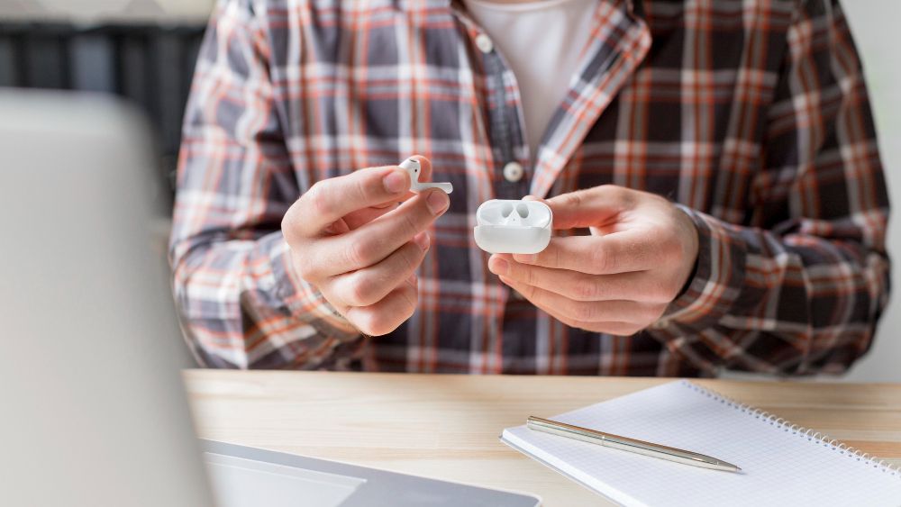 sitting at desk getting ready for meeting with earbuds