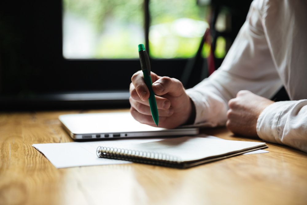 student taking notes in a small notebook