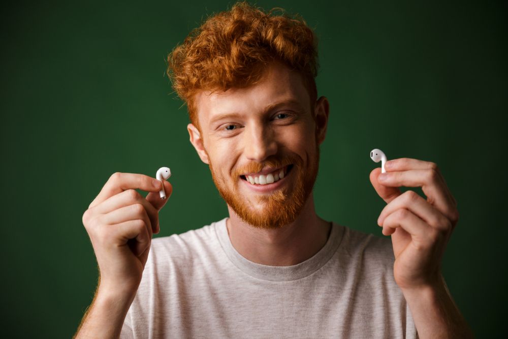 man holding up working airpods